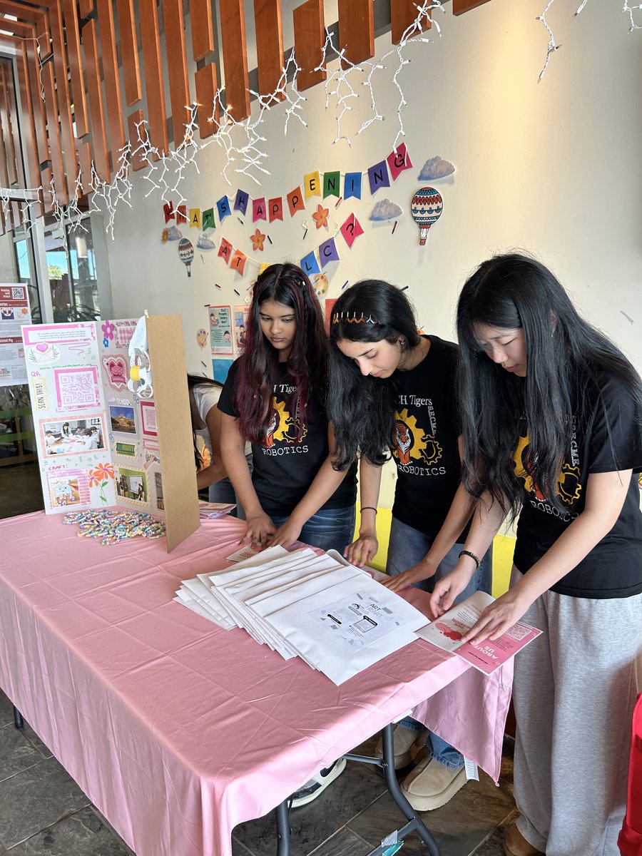 Members setting up the Art from the Heart booth with the display board and goody bags