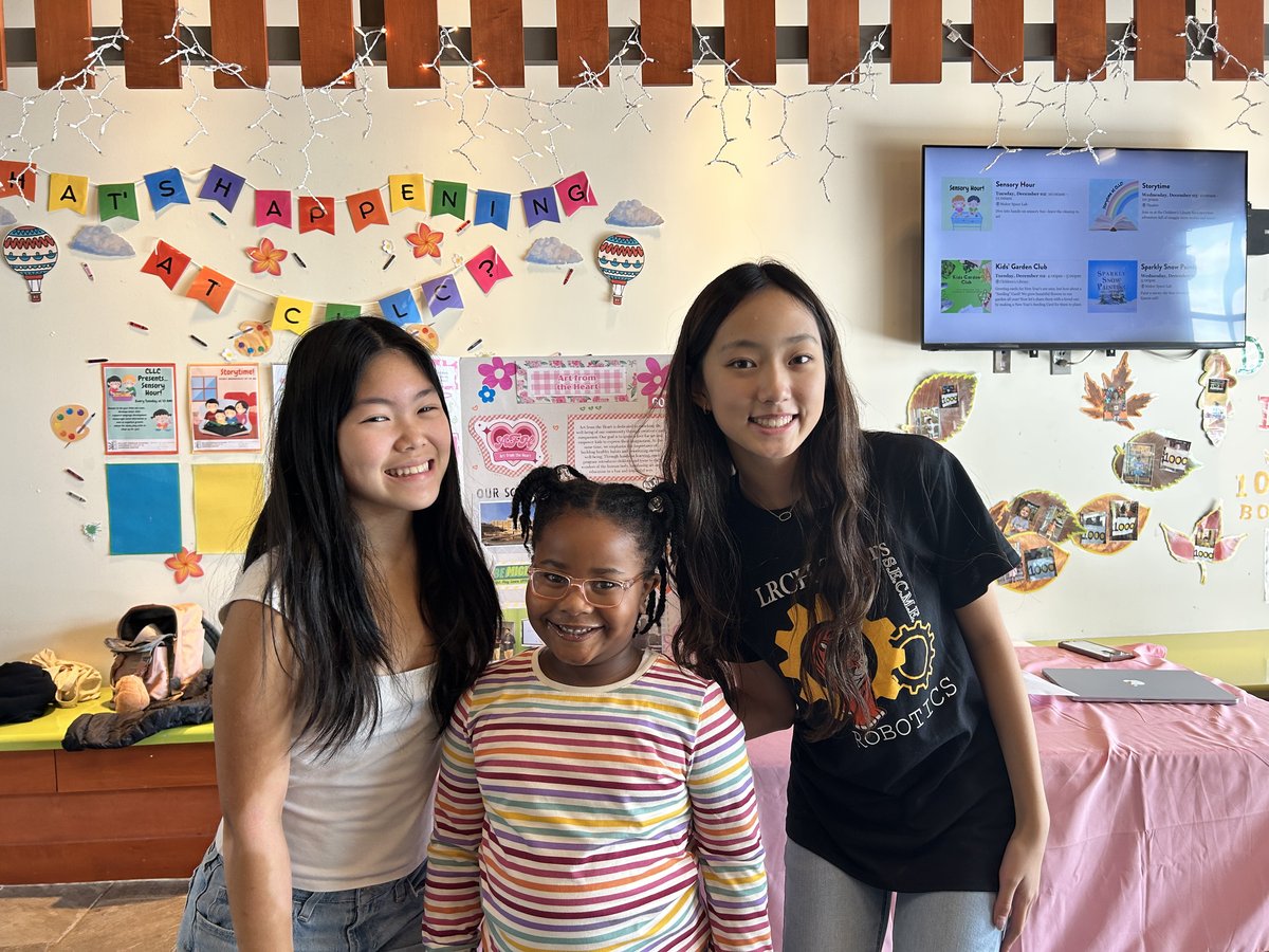 Members posing with a young library visitor at the booth