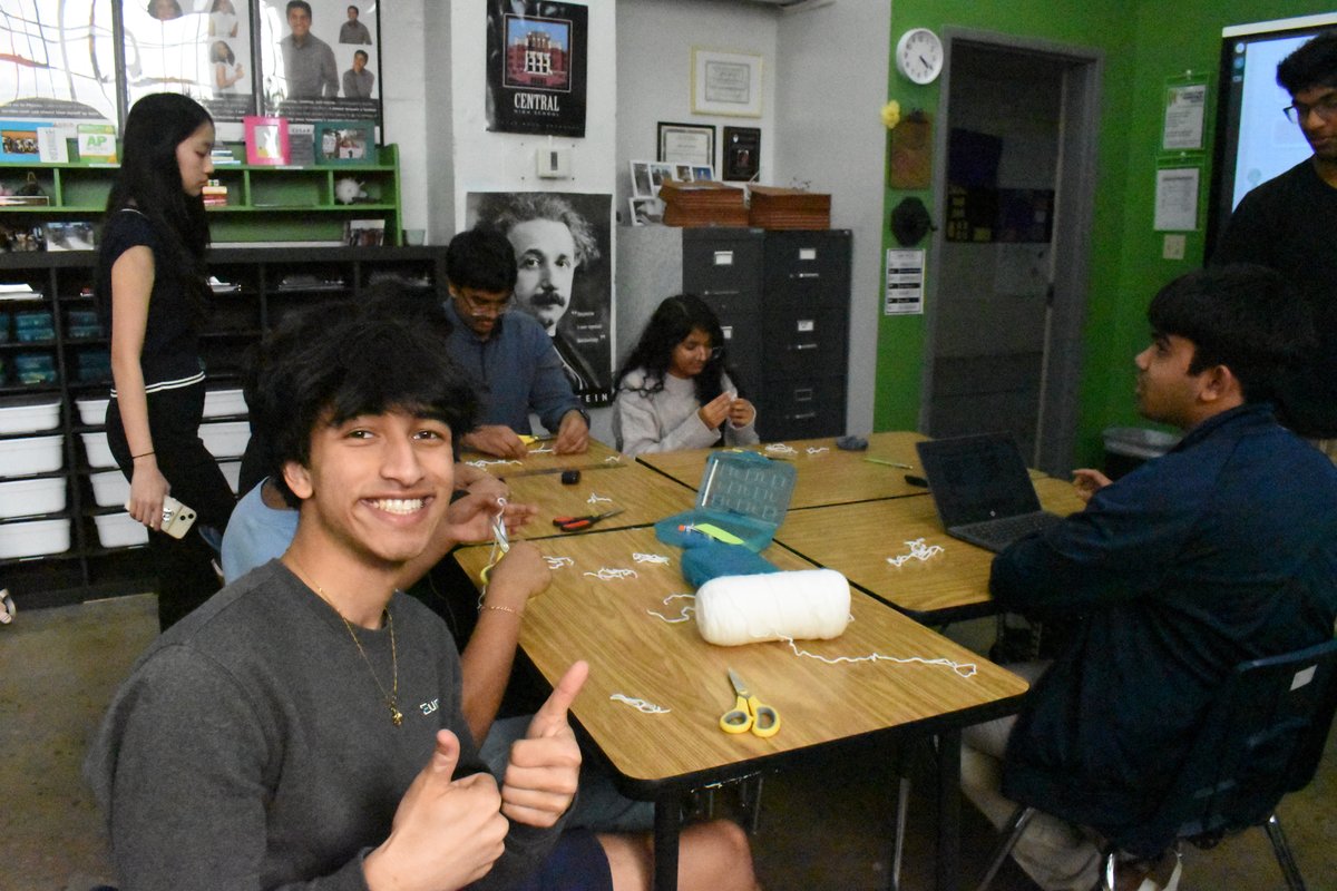 Member giving a thumbs up while assembling mini garden kits