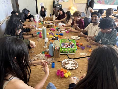 Members filling maraca kits around a long table