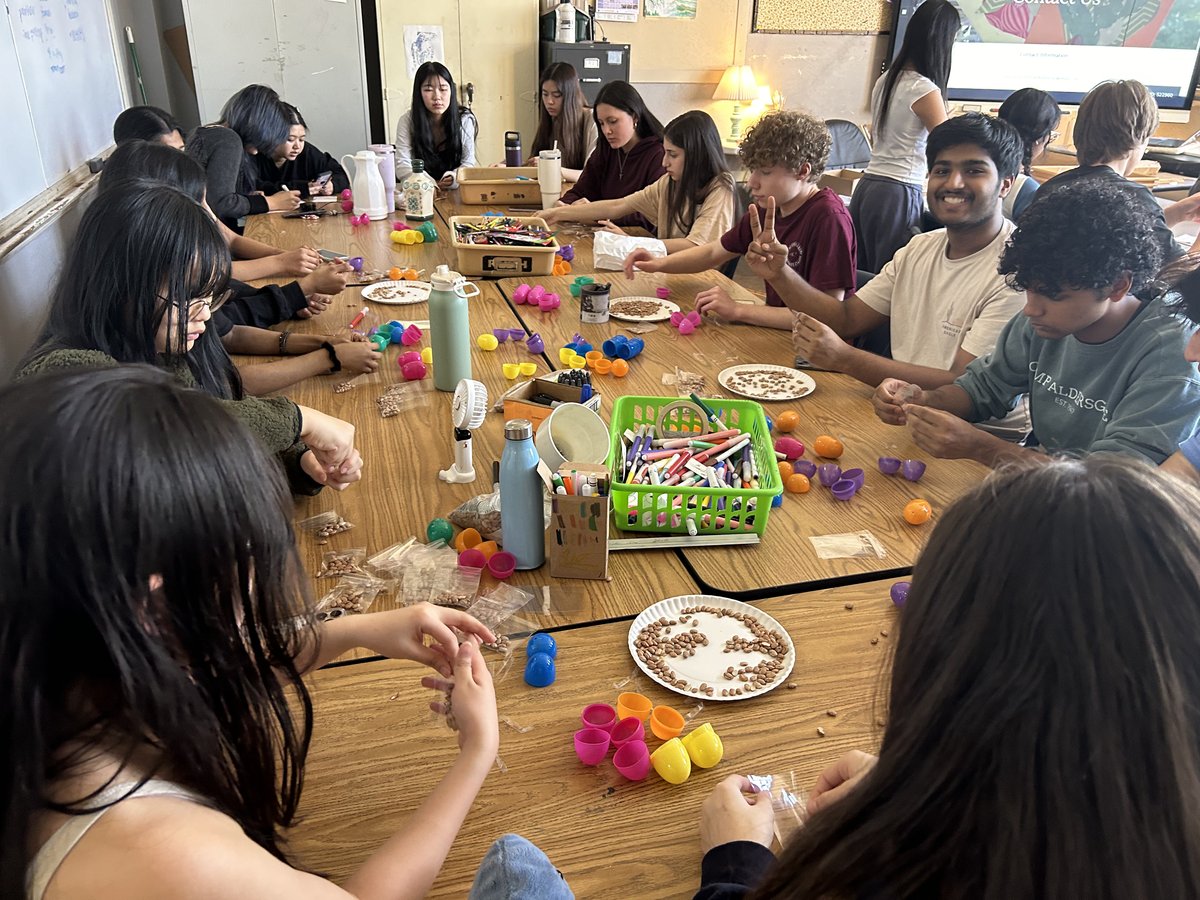 Members assembling colorful maraca goody bag kits
