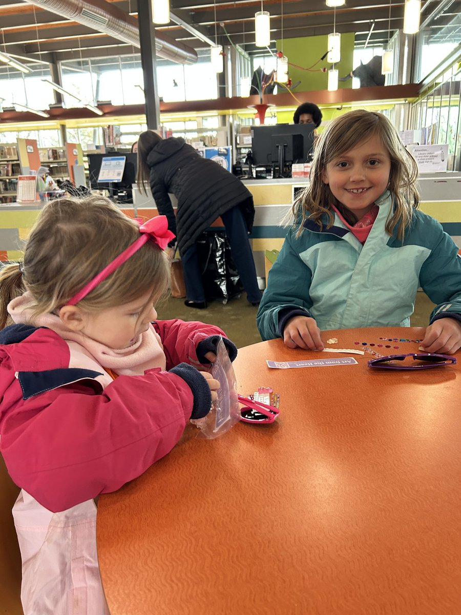 Young visitors decorating sunglasses at the booth table