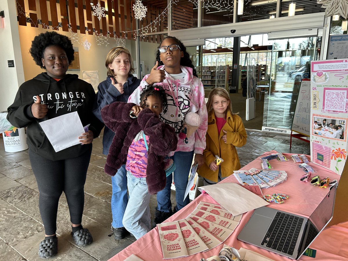 Visitors giving a thumbs up at the booth